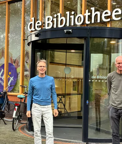 Twee mannen van het energieloket staan voor de bibliotheek 