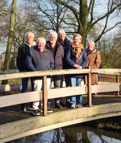 Foto van buurtteam Langenbeek op een brug in de wijk in het zonnetje