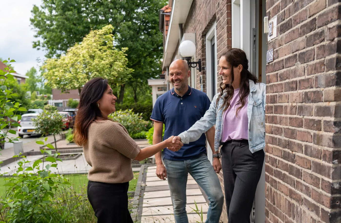 Buren schudden hand van bezoeker tijdens Duurzame Huizenroute