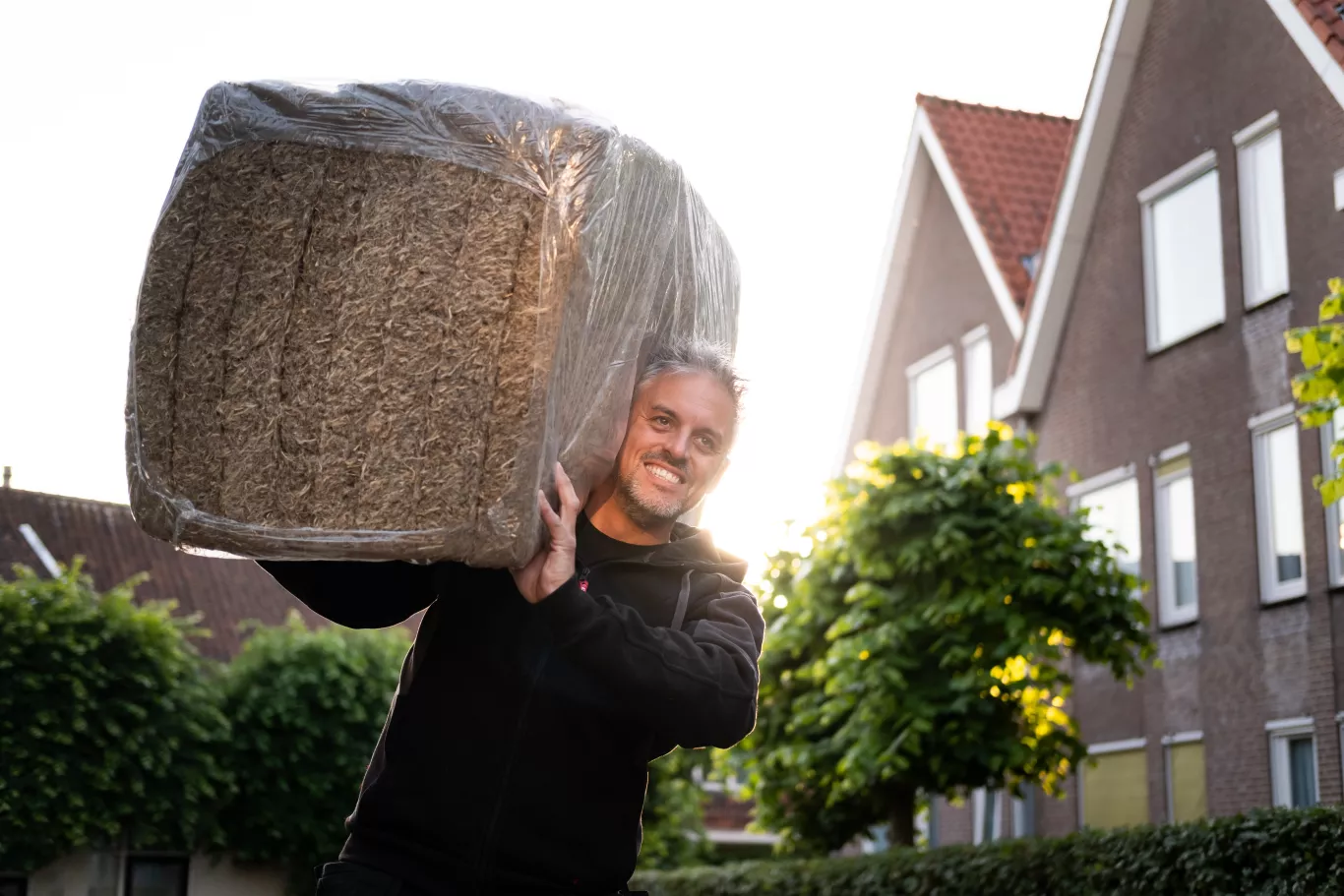 Man draagt isolatiemateriaal op zijn schouders